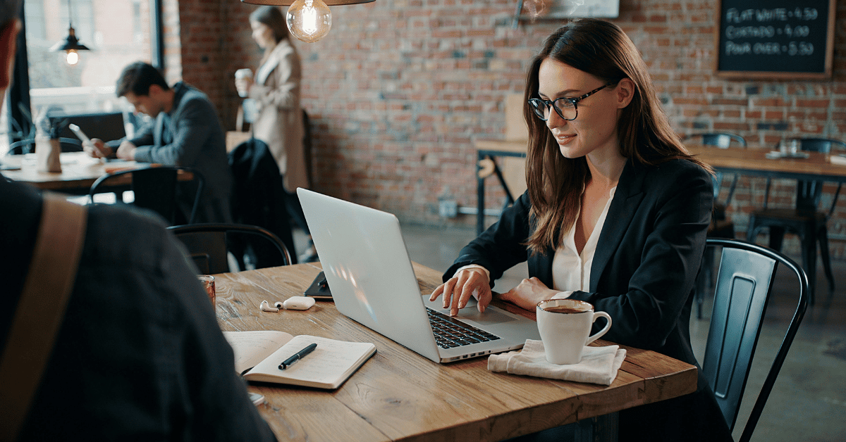 vrouw zit achter laptop in een cafe 