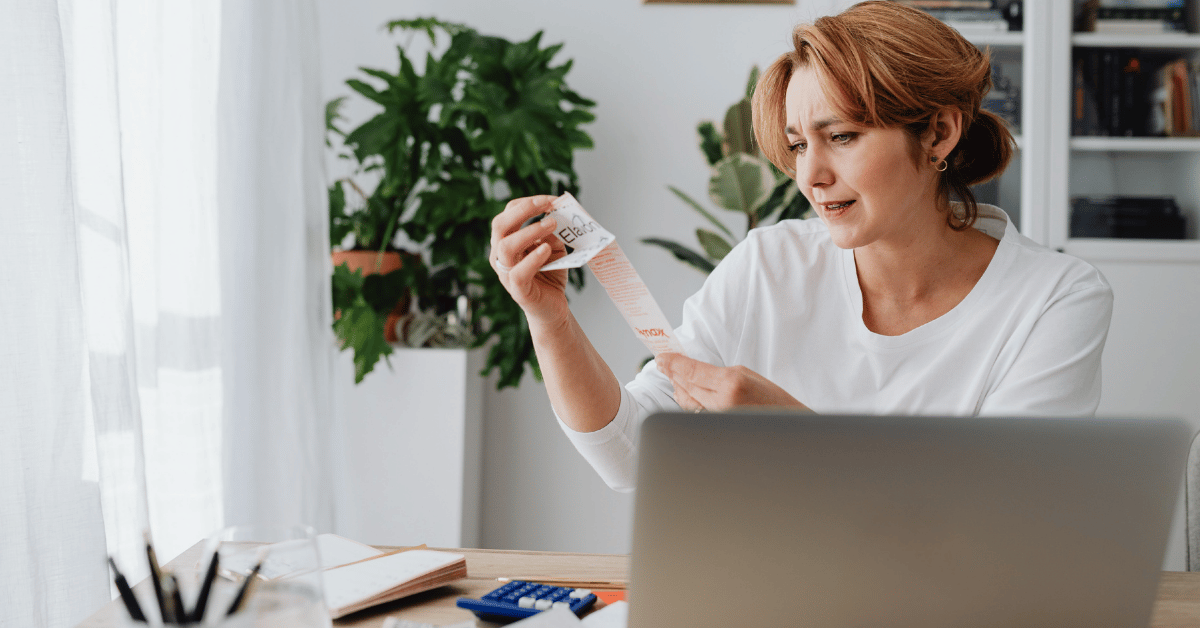 vrouw bekijkt bonnetje achter haar laptop